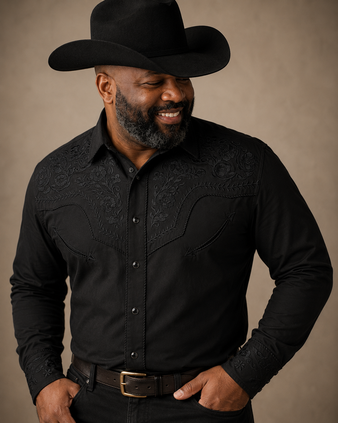 Black floral embroidered men's western pearl snap shirt - front view with cowboy hat on model